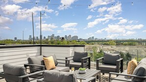An outdoor seating area with gray furniture and a city view. - Revival-rooftop Deck/hot Tub- Mins to Broadway (Nashville)