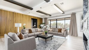 Ein modernes Wohnzimmer mit Ecksofa, Couchtisch und Kamin.