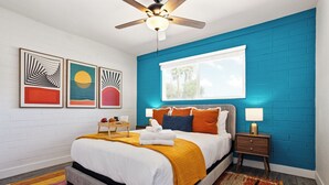 A modern bedroom with a bed, a nightstand, a ceiling fan, and artwork on the wall. - Dawn - Walk to Old Town & Entertainment District (Scottsdale)