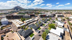 A commercial area with multiple buildings, parking lots, and a mountain in the background. - Dawn - Walk to Old Town & Entertainment District (Scottsdale)