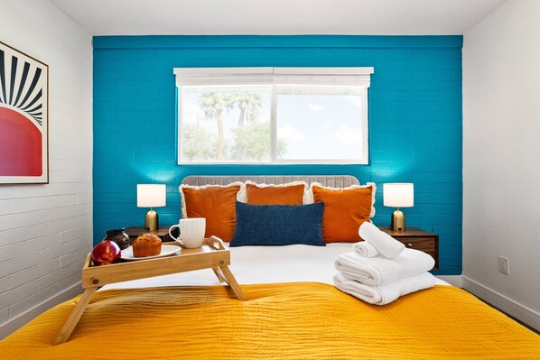 A room with a bed, a window, a nightstand, a tray with breakfast items, and a wall art piece. - Dawn - Walk to Old Town & Entertainment District (Scottsdale)