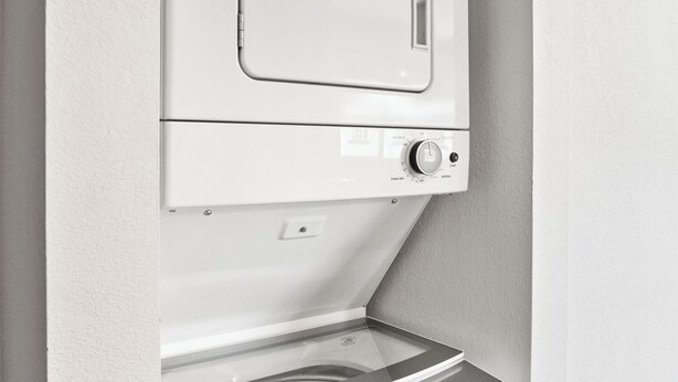A compact washer and dryer unit with a control panel, installed in a corner of a room with white walls. - Dawn - Walk to Old Town & Entertainment District (Scottsdale)