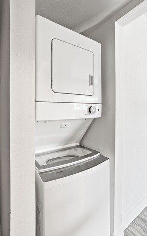 A compact washer and dryer unit with a control panel, installed in a corner of a room with white walls. - Dawn - Walk to Old Town & Entertainment District (Scottsdale)