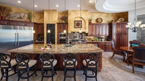 A kitchen with a large island, bar stools, and a dining area with a chandelier. - Desert Mountain Majesty - Private Spa&guest Casita (Cave Creek)