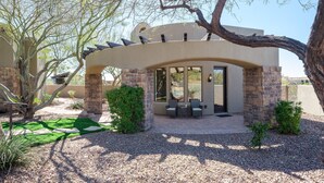 A covered outdoor seating area with stone pillars, a pergola, and a view of a swimming pool. - Desert Mountain Majesty - Private Spa&guest Casita (Cave Creek)