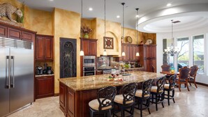 A spacious kitchen with a large island, wooden cabinets, and modern appliances. - Desert Mountain Majesty - Private Spa&guest Casita (Cave Creek)