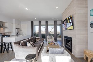 Uma sala de estar moderna com sofá, mesa de centro e lareira.