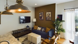A living room with a sofa, armchairs, a coffee table, a lamp, and a large pendant light. - Country Lyric - Mins to Downtown - Rooftop Deck (Nashville)