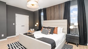 A modern bedroom with a large bed, a bedside table, a nightstand, and a window with curtains. - Ballad Blues - Rooftop Patio - Mins to Broadway (Nashville)