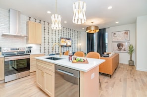 A modern kitchen with a central island, stainless steel appliances, and pendant lighting. - Ballad Blues - Rooftop Patio - Mins to Broadway (Nashville)