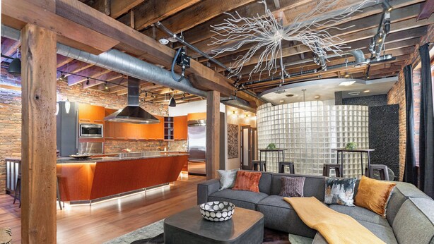 A modern kitchen with a central island, a dining area with a sofa and a coffee table, and a living room with a large window. - Jamloft - Printers Alley - Walk to Broadway (Nashville)