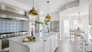 A modern kitchen with white cabinetry, stainless steel appliances, and pendant lighting. - Majestic Mountain Mansion-heated Pool-guest House (Paradise Valley)