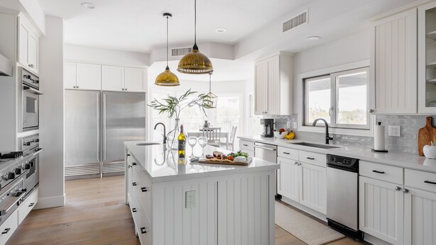 A modern kitchen with white cabinetry, a central island, stainless steel appliances, and pendant lighting. - Majestic Mountain Mansion-heated Pool-guest House (Paradise Valley)