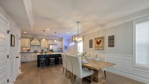 A spacious kitchen with a central island, pendant lighting, and a dining area with a wooden table and chairs. - Gulch Melody - Private Rooftop - Heart of Gulch (Nashville)