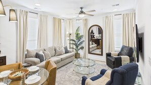 A living room with a sofa, armchairs, a coffee table, and a television. - Woodwind - Minutes to Broadway -walk to Breweries (Nashville)