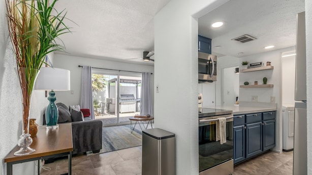 A modern kitchen with a built-in oven, a coffee machine, and a small dining area with a table and chairs. - Blue Abode - Old Town Scottsdale - Pool &bbq Grill (Scottsdale)