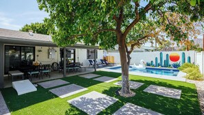 A backyard with a swimming pool, a dining area, and a tree. - Old Town Art Deco - Pool&fire Pit - In Old Town (Scottsdale)