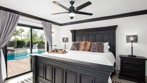 A bedroom with a large bed, a ceiling fan, a nightstand, and a view of a swimming pool. - Modern Roose-pool Heat Available-hot Tub- Old Town (Scottsdale)