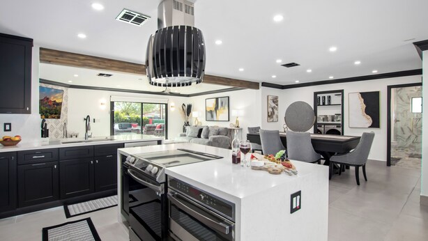 A modern kitchen with a central island, built-in ovens, and a large range hood. - Modern Roose-pool Heat Available-hot Tub- Old Town (Scottsdale)