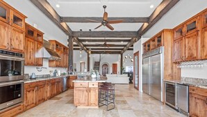 A spacious kitchen with wooden cabinets, stainless steel appliances, and a central island.