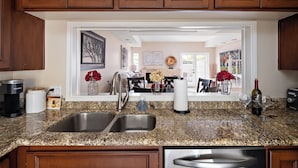A kitchen with granite countertops, stainless steel sinks, and wooden cabinets. - Biltmore Bliss-pool-pickeball-gym-mountain Views (Phoenix)