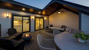 An outdoor patio area with a fire pit, wicker furniture, and a ceiling fan. - Elevate - Modern Luxury - Stunning City Views (Nashville)