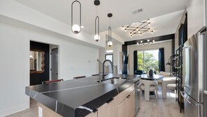 A modern kitchen with a large island, stainless steel appliances, and pendant lighting. - Elevate - Modern Luxury - Stunning City Views (Nashville)