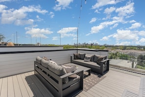 A rooftop terrace with two grey sofas and a coffee table, featuring a city skyline view. - Groovy -rooftop Patio w/ Hot Tub -mins to Broadway (Nashville)