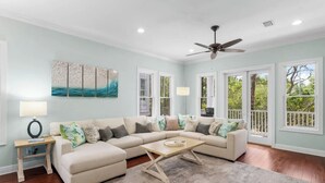A living room with a sectional sofa, a coffee table, a ceiling fan, and a large window with a view of greenery. - 🦩Book Me Baby! Grayt Escape Private Home at The Preserve🦩 (Santa Rosa Beach)