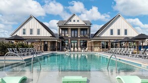 Et hotel med centralt beliggende pool, liggestole og parasoller.