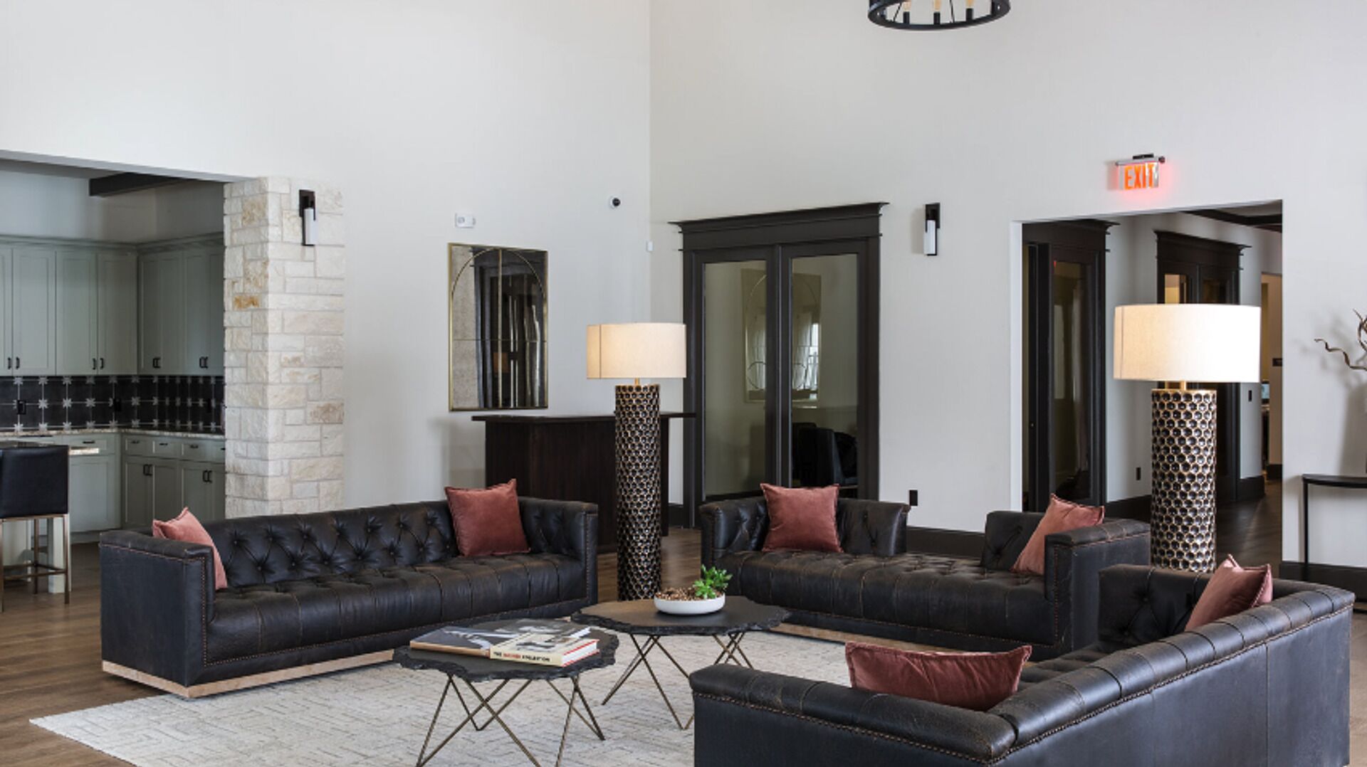 A modern living room with leather sofas, a coffee table, and two floor lamps.