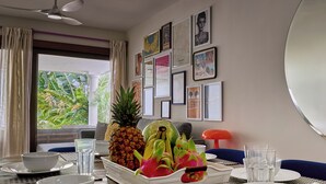 Comedor con una mesa dispuesta para dos personas, con frutero, cuencos blancos y vasos.