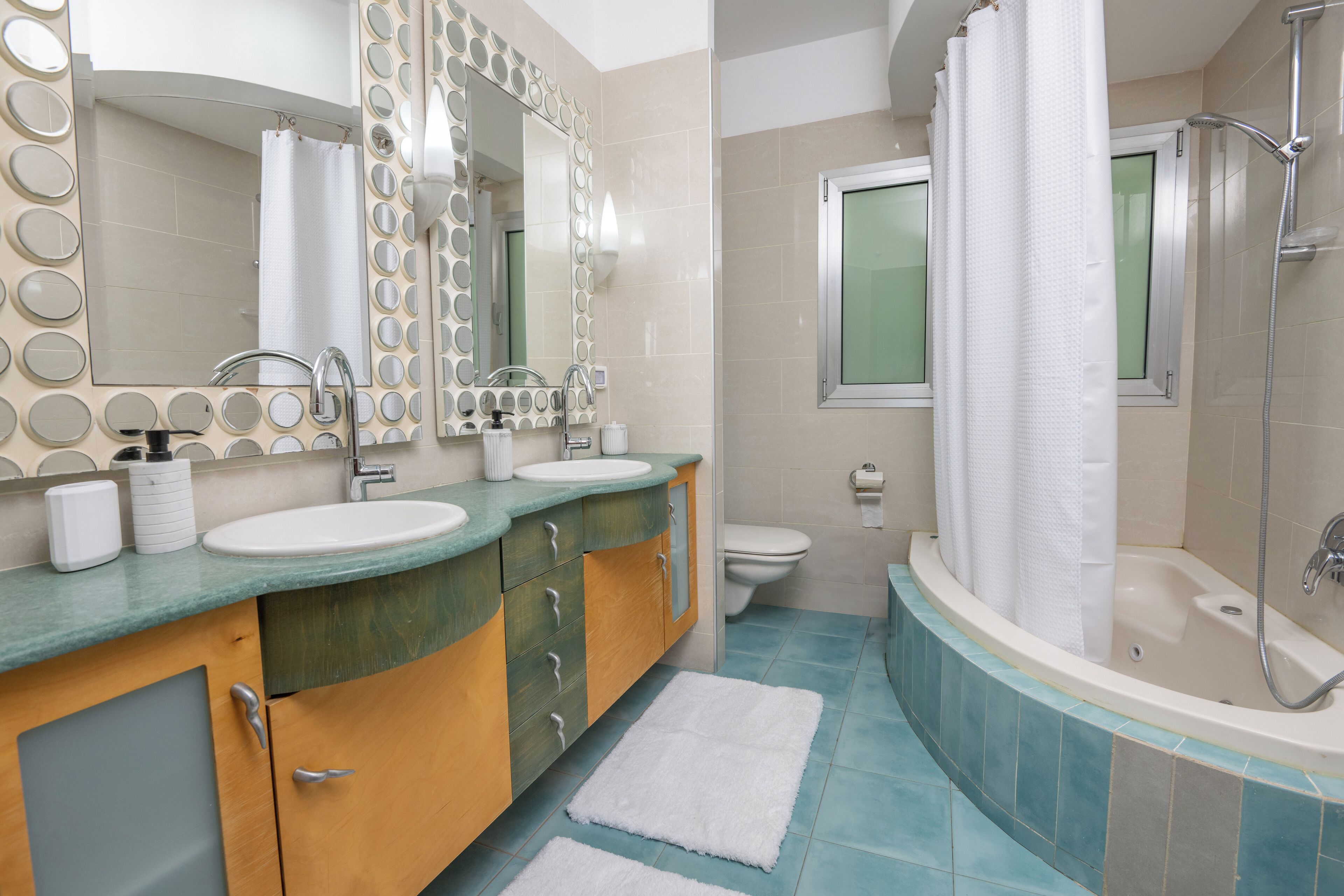 Une salle de bain moderne avec deux lavabos, un grand miroir, une douche et des toilettes.