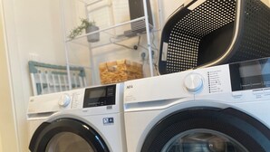 Vue de face d’un lave-linge à chargement frontal doté d’un écran numérique et d’un panneau de commande.