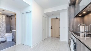 Un apartamento moderno con baño, cocina y pasillo.