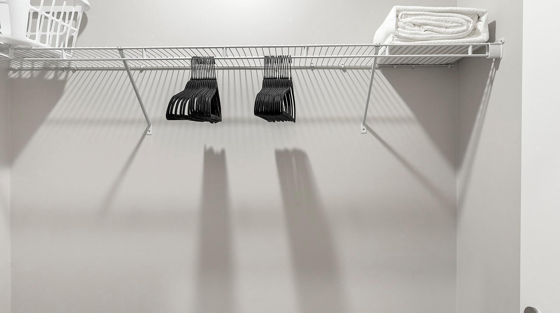A laundry area with a metal rack holding folded towels and a basket.
