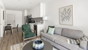 Una sala de estar moderna con un sofá gris, un sillón verde y una mesa de centro.