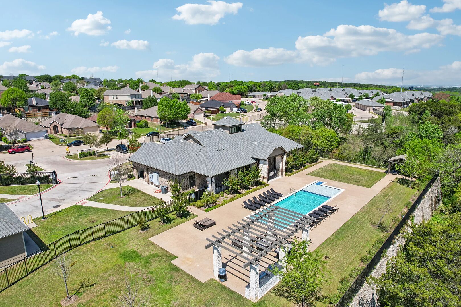 Un quartier résidentiel doté d’une piscine, de maisons et d’un grand immeuble avec un garage.