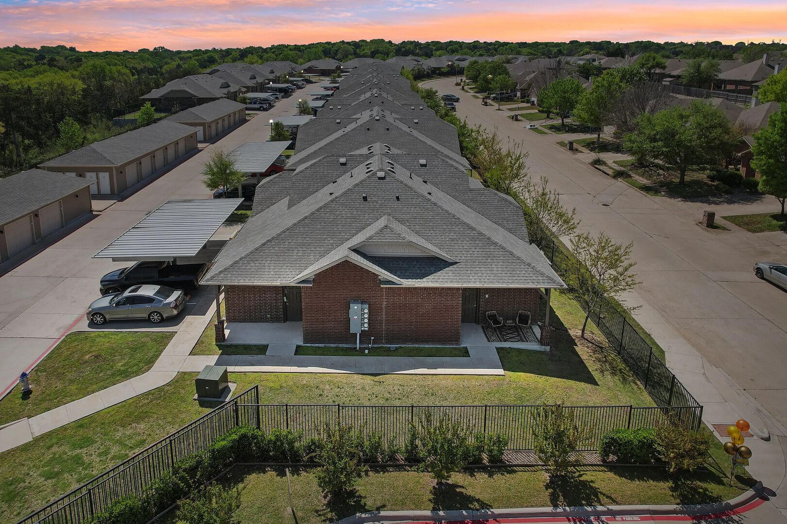 A row of townhouses with a central building featuring a brick facade and a sloped roof.
