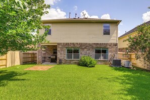 A two-story house with a brick facade, a small front yard with a lawn, and a satellite dish on the roof. - Fish & Hike: Pet-Friendly Humble Home w/ Yard (Humble)