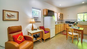 A compact kitchen with a refrigerator, microwave, and stove. There is a dining area with a table and chairs. - Fish, Raft & Hike: Southwest OR Couple’s Retreat! (Trail)