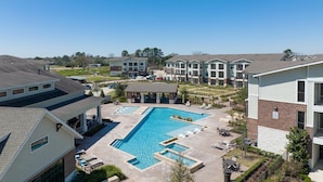 A residential complex with a central swimming pool, outdoor seating, and a covered patio area. - Landing | Beautiful 1BD, Courtyard, Pool (Katy)