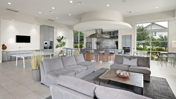 A spacious living area with a grey sofa set, a coffee table, and a TV mounted on the wall. - Landing | Stylish 1BD, Yoga Studio, Clubhouse (Kyle)