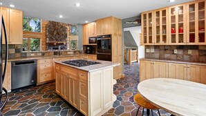 A spacious kitchen with wooden cabinets, a stone backsplash, and a built-in oven. - Luxury Mountain Cabin: Hot Tub, Mtn Views, Game Room - Sleeps 10 - Winter Park (Fraser)