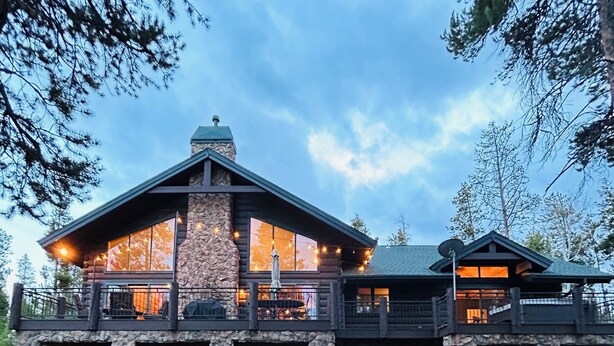 A log cabin with a stone chimney, large windows, and a balcony. - Luxury Mountain Cabin: Hot Tub, Mtn Views, Game Room - Sleeps 10 - Winter Park (Fraser)