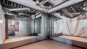 A modern, industrial-style room with exposed ductwork, a ladder, and a large mirror reflecting the room's interior. - Landing | Incredible 1BD, Gym, Pool (Spring Valley)