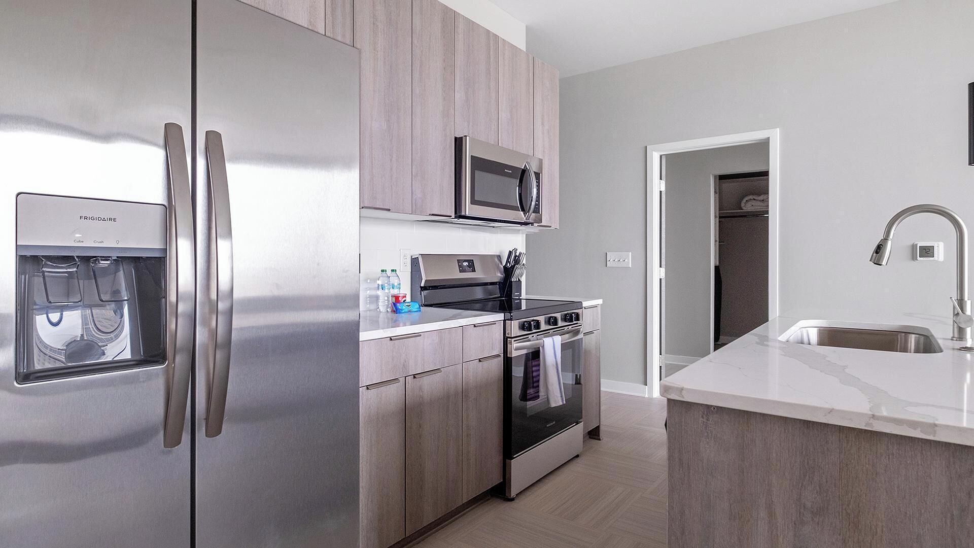 A modern kitchen with stainless steel appliances, a built-in microwave, and a water dispenser.