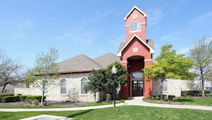 Une église dotée d’un clocher rouge, de murs en pierre et d’une pelouse bien entretenue.