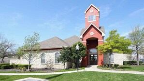 A church with a red tower, stone walls, and a well-maintained lawn. - Landing | Beautiful 1BD, Pool, Gym (Fort Worth)