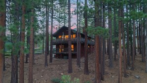 A cabin surrounded by tall pine trees, with a deck and multiple windows. - Secluded Incline Village Stay w/ Deck Near Diamond Peak & Lake Cloud 9 and 1/2 by Avantstay (Incline Village)